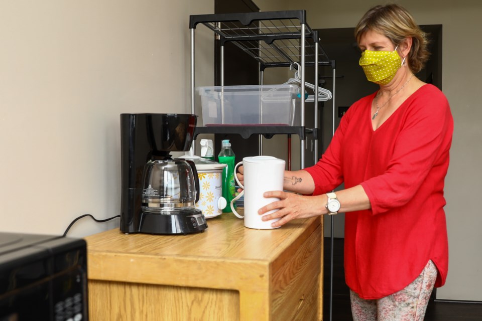 Banff YWCA CEO, Connie MacDonald sets up a “self isolation room” at the YWCA with small kitchen appliances on Friday (June 26). The YWCA has eight rooms available self isolation because of COVID-19 for Banff residents.  EVAN BUHLER RMO PHOTO⁠