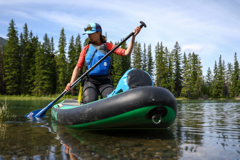 Deidre Maceachern launches her paddle board into the Bow River near the Banff Canoe Club. EVAN BUHLER RMO PHOTO⁠