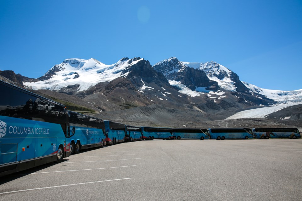 Buses sit with the parking lot after operations were ceased in wake of the sightseeing bus rollover at the Columbia Icefields, Monday (July 20). Three people were killed and more than a dozen others were critically injured when a glacier sightseeing bus rolled on Saturday. EVAN BUHLER RMO PHOTO⁠