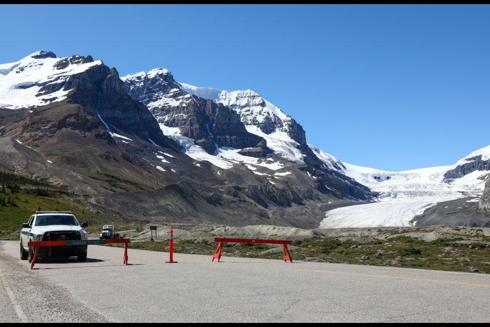 A Parks Canada patrols the road into the scene of the sightseeing bus rollover at the Columbia Icefields, Monday (July 20). Three people were killed and more than a dozen others were critically injured when a glacier sightseeing bus rolled on Saturday. EVAN BUHLER RMO PHOTO⁠
