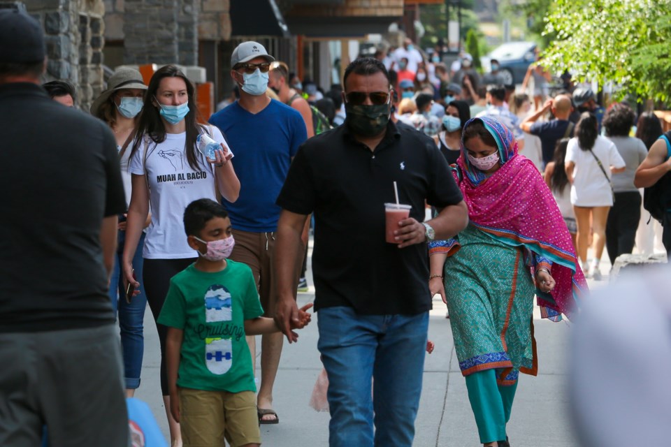Tourists walk along Banff Avenue wearing face masks on Saturday (Aug. 1). Friday marked the first day the town’s mandatory mask by-law took effect. EVAN BUHLER RMO PHOTO⁠