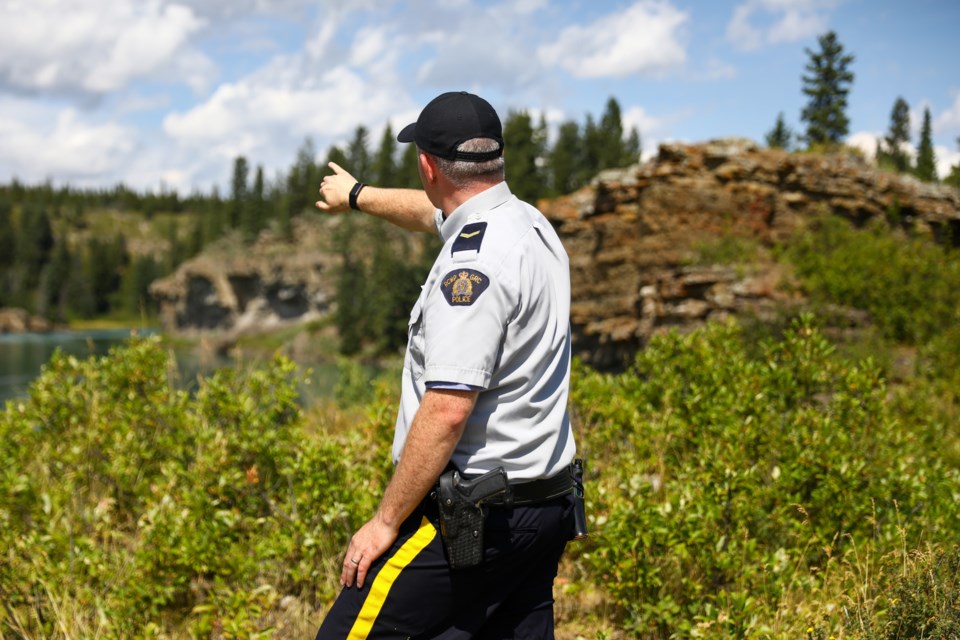 Cochrane RCMP Cpl. Troy Savinkoff points to to the spot in the Bow River where the suspected drowning victim Blessing Paul, 16, disappeared near the Seebe Dam, on Tuesday (Aug. 11). EVAN BUHLER RMO PHOTO