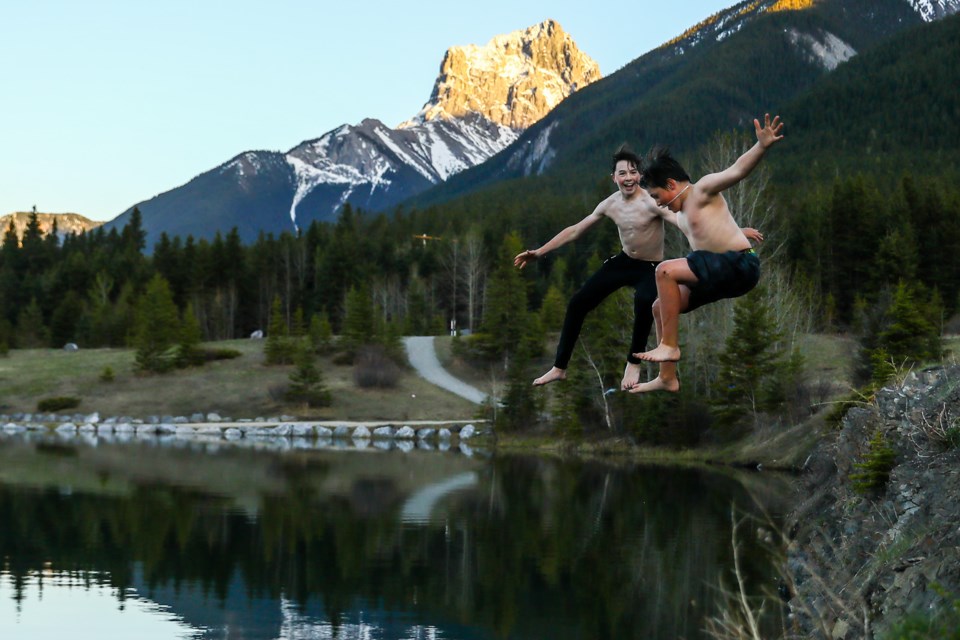 Hudson Hunt, left, and Callum Sheldon jump into Quarry Lake in Canmore on Saturday (May 22). EVAN BUHLER RMO PHOTO