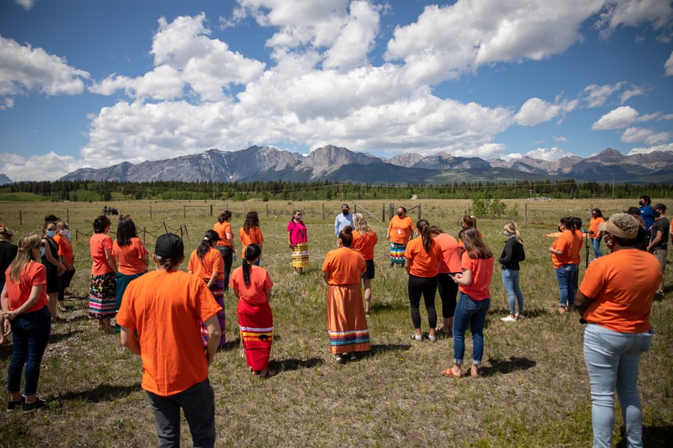 Stoney Nakoda elder Krista Hunter, left, and Chris Goodstoney speak to a gathering of more than 30 supporters before performing a smudging ceremony in memory of the 215 children found in a mass grave on the grounds of the Kamloops Residential School on Friday (June 4). EVAN BUHLER RMO PHOTO