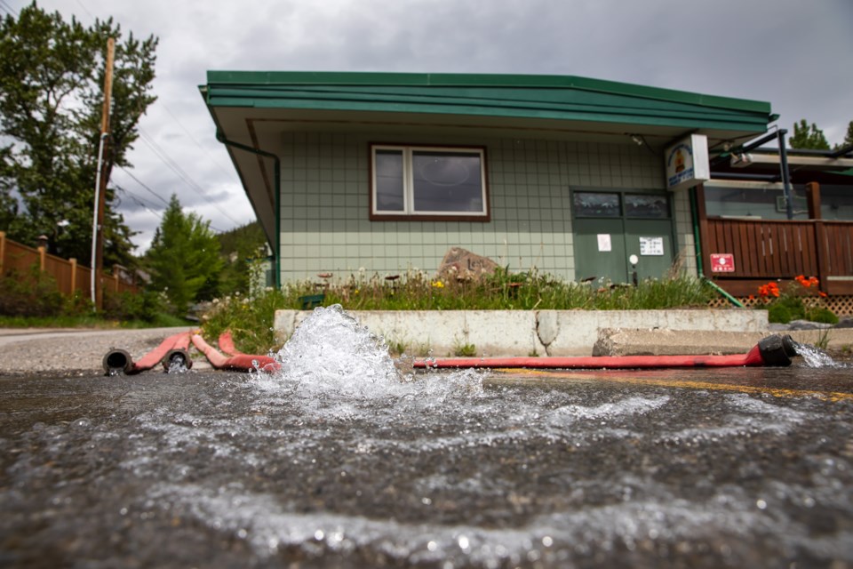 Water is pumped out of the basement of the Exshaw Community Centre on Tuesday (June 8). EVAN BUHLER RMO PHOTO