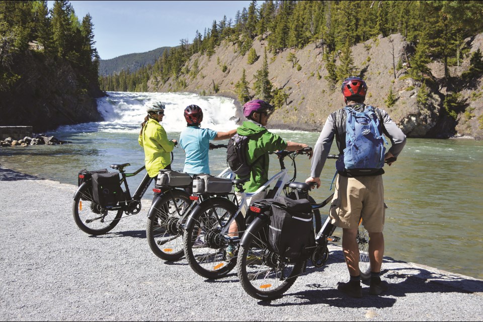 Riders of White Mountain Adventures new e-bike tour briefly stop to take in the wonders of Bow Falls in Banff. JORDAN SMALL RMO PHOTO