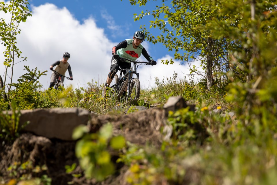 Lochlan Moffatt, left, and Alex Jessey mountain bike down a steep and technical trail at the Canmore Nordic Centre on Saturday (June 12). EVAN BUHLER RMO PHOTO