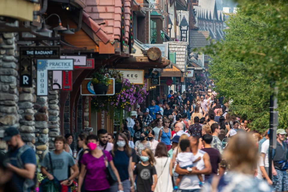 Hundreds of pedestrians walk along the sidewalk on Banff Avenue in Banff on Saturday (Aug. 14). Banff council voted to forego bringing back a temporary indoor mask bylaw, but set a vaccination rate target for the community to achieve they hope will incentivize people to get their COVID-19 shot. EVAN BUHLER RMO PHOTO