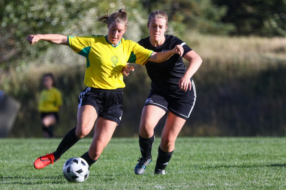 Anna Marino of the Canmore Collegiate girls soccer team holds off a Foothills Composite High School defender as she makes her way towards goal during a game at Millennium Field on Tuesday (Sept. 21). EVAN BUHLER RMO PHOTO