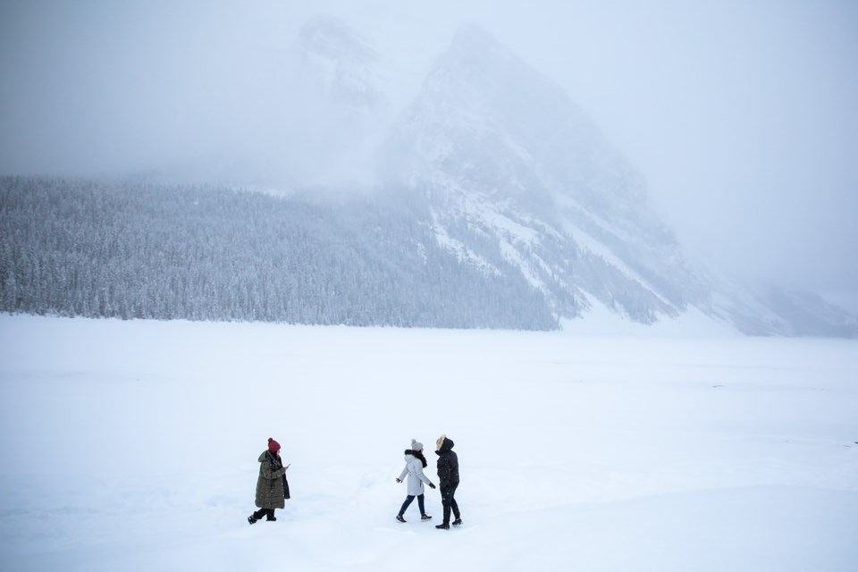 A trio of people walks along the frozen shore of Lake Louise during a light snowfall on Friday (Nov. 26). EVAN BUHLER RMO PHOTO
