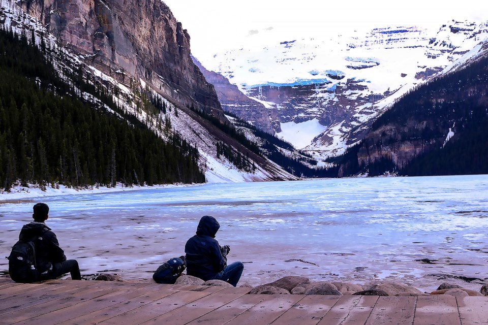 Mark Anders, left, and Ben Alexander sit on the boardwalk at Lake Louise on Friday (May 27).

GREG COLGAN RMO PHOTO