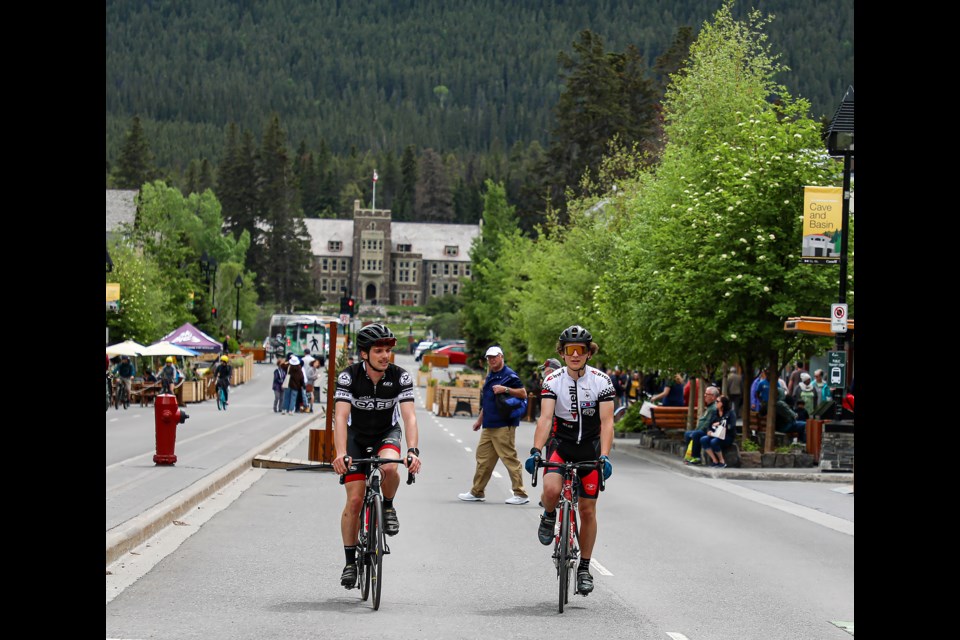 Lucas Saedesky, right, and Tom Stephen cycle on Banff Avenue in downtown Banff in June 2022.

RMO FILE PHOTO