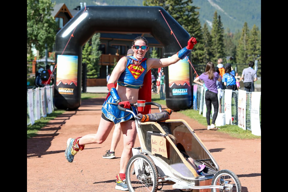 Karen Messenger smiles as she does Superman's flying pose at the finish line in the Canada Day family fun, run and walk on Friday (July 1) in Canmore. JUNGMIN HAM RMO PHOTO