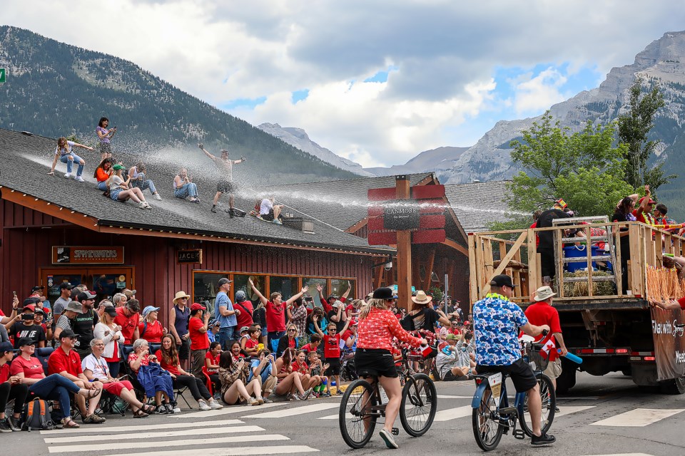 People on the roof of a downtown Canmore business get spray from a float during the Canada Day parade in Canmore on Friday (July 1). JUNGMIN HAM RMO PHOTO