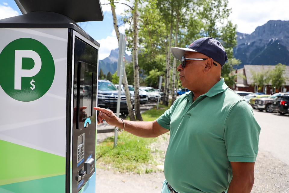 Vishnu Lutchman, a tourist from Ontario, pays for parking in downtown Canmore on Tuesday (July 5). JUNGMIN HAM RMO PHOTO