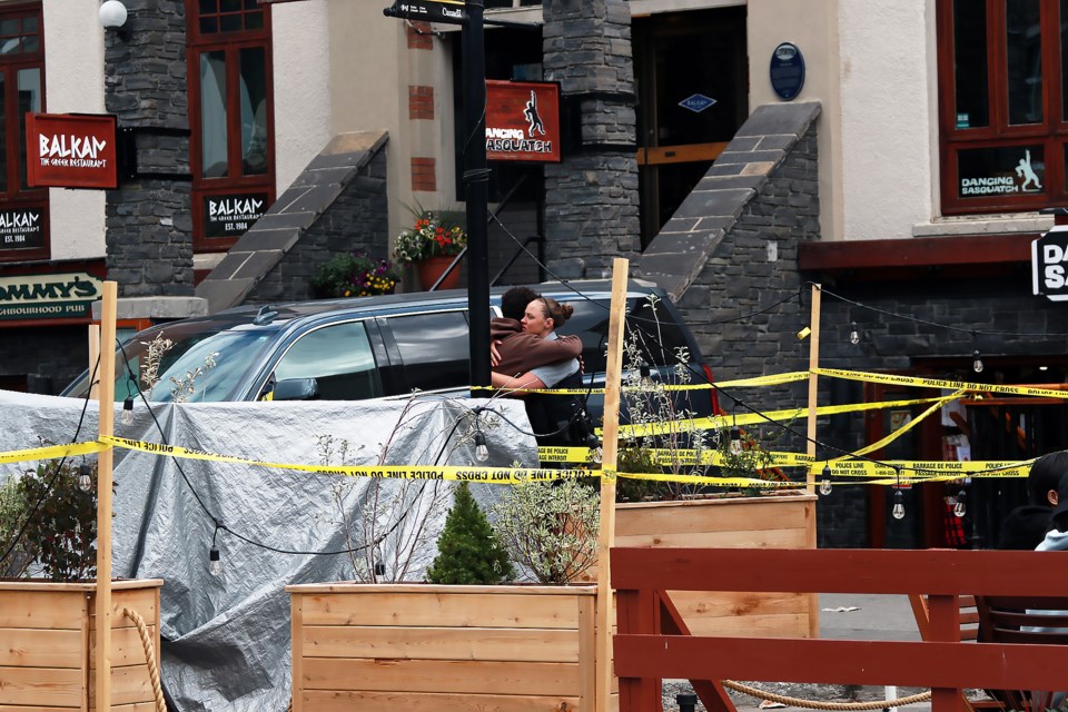 A Banff RCMP officer and local hug outside Dancing Sasquatch after Banff resident Ethan Enns-Goneau was killed at the Banff bar in the early morning hours of Aug. 5, 2022.

RMO FILE PHOTO
