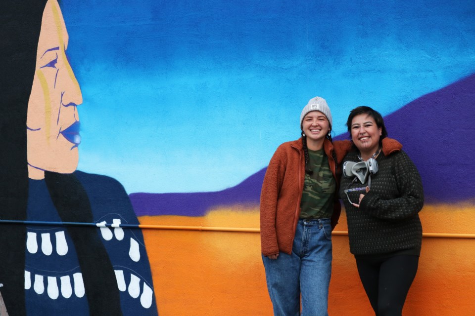 Kayla Bellerose (aka bb eskwew), left, and Cheyenne (Chey) Suwatâgâ-Mu's Three Sisters mural is the first piece of public Indigenous art in Canmore, pictured here in progress. It is located downtown on the west-facing wall at 907 7 Ave. and was unveiled to the public Friday (Sept. 16). JESSICA LEE RMO PHOTO