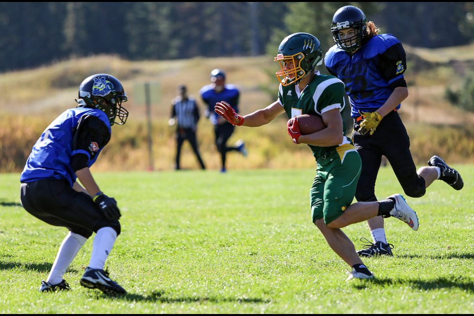 Canmore Wolverines Bryton Kapitza (No. 5) prepares to stiff arm a Carstairs Kodiaks defender in a game at Millennium Park on Saturday (Oct. 1). JUNGMIN HAM RMO PHOTO