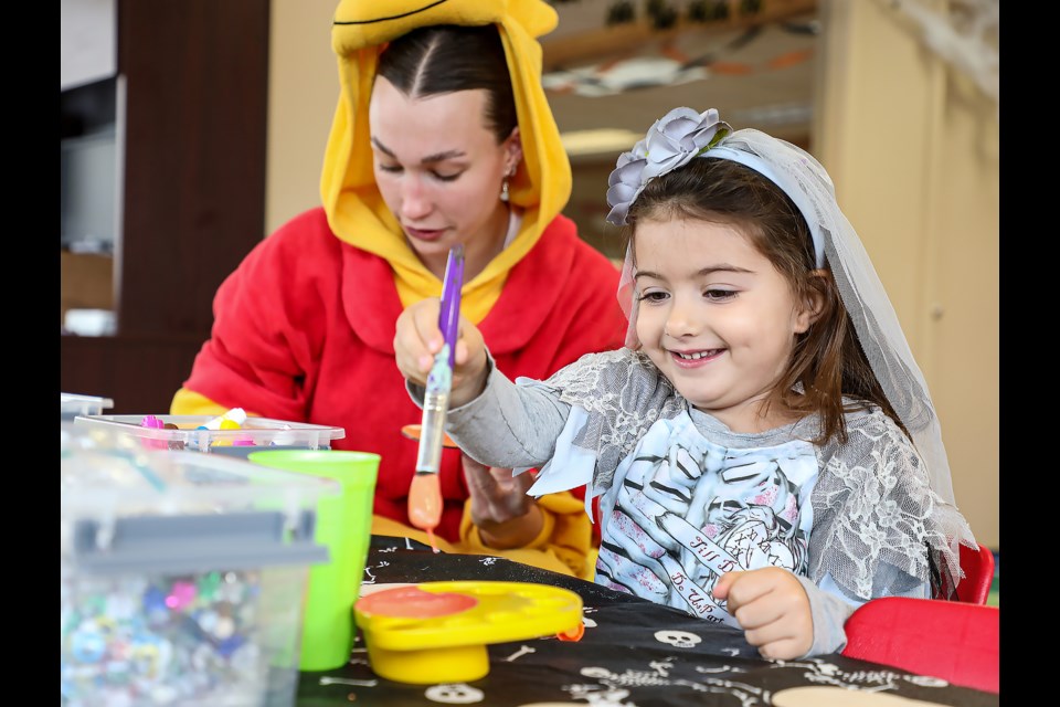 Emma Almari, right, wears a skeleton dress and paints a pumpkin picture at the Family Connection Centre open house in Canmore on Saturday (Oct. 22). JUNGMIN HAM RMO PHOTO 