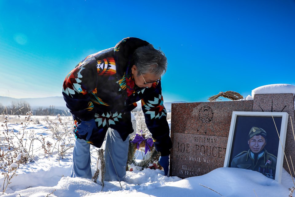 Tina Fox cleans snow from the memorial headstone of her uncle Joe Poucette at Big Stoney Cemetery near Mînî Thnî on Tuesday (Nov. 8). Rifleman Joe Poucette was the only person from Stoney Nakoda First Nation to serve in the Second World War. JUNGMIN HAM RMO PHOTO