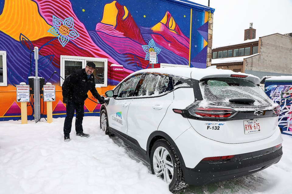 Canmore Mayor Sean Krausert prepares to open the door for one of two of the Town's first electric vehicles at the charging station in Canmore on Wednesday (Nov. 16). JUNGMIN HAM RMO PHOTO 