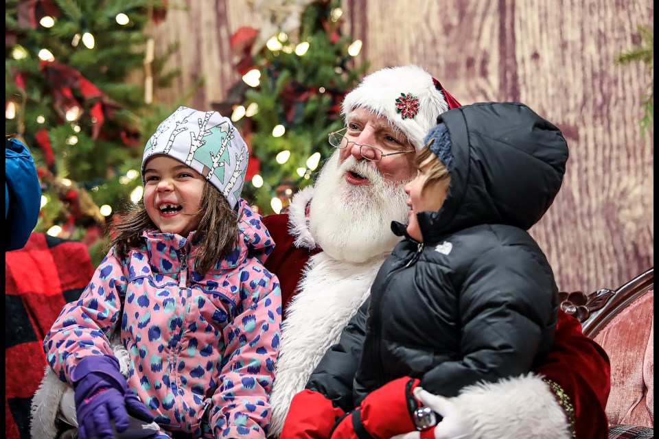 Frida Karlos, left, and James Charles Mendelman take pictures with Santa Claus at the Banff Christmas Market on Friday (Nov. 18). JUNGMIN HAM RMO PHOTO 