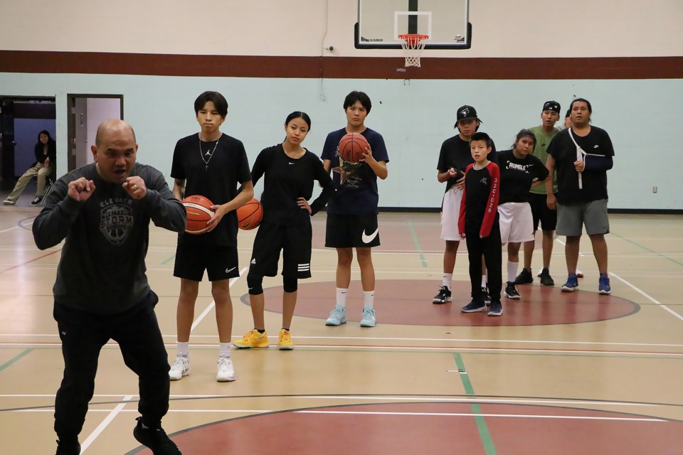 Founder and General Manager of Calgary's United Storm Basketball club Tony Tan, left, demonstrates a drill during an instructional clinic at the Morley Gymnasium Saturday (Dec. 3). 

JESSICA LEE RMO PHOTO