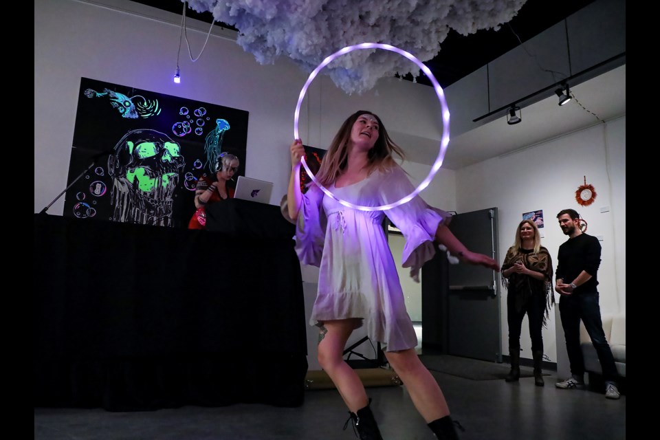 Performer Basia Banas performs with a glow-in-the-dark hula hoop dance at the HeARTburn gallery exhibition's opening reception at artsPlace in Canmore on Wednesday (Feb. 8). JUNGMIN HAM RMO PHOTO