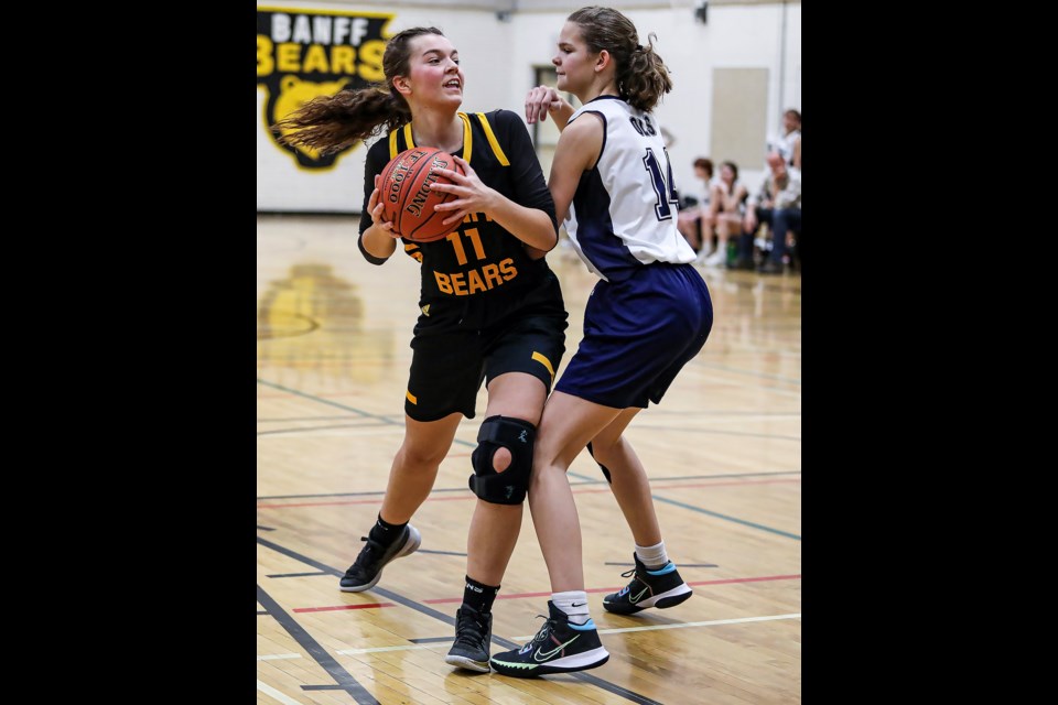Banff Bears Grace Gibson, left, and OLS Avalanche Ariane Thomson battle for the ball during the senior girls basketball tournament at Banff Community High School on Friday (Feb. 10). The Bears beat the Avalanche 53-28. JUNGMIN HAM RMO PHOTO