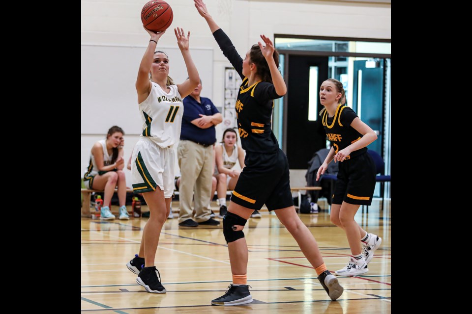 Canmore Wolverines Jordan Lakusta, elft, shoots over the block attempt of Banff Bears Grace Gibson during the senior girls basketball tournament semifinal at Banff Community High School on Saturday (Feb. 11). The Wolverines beat the Bears 48-33. JUNGMIN HAM RMO PHOTO