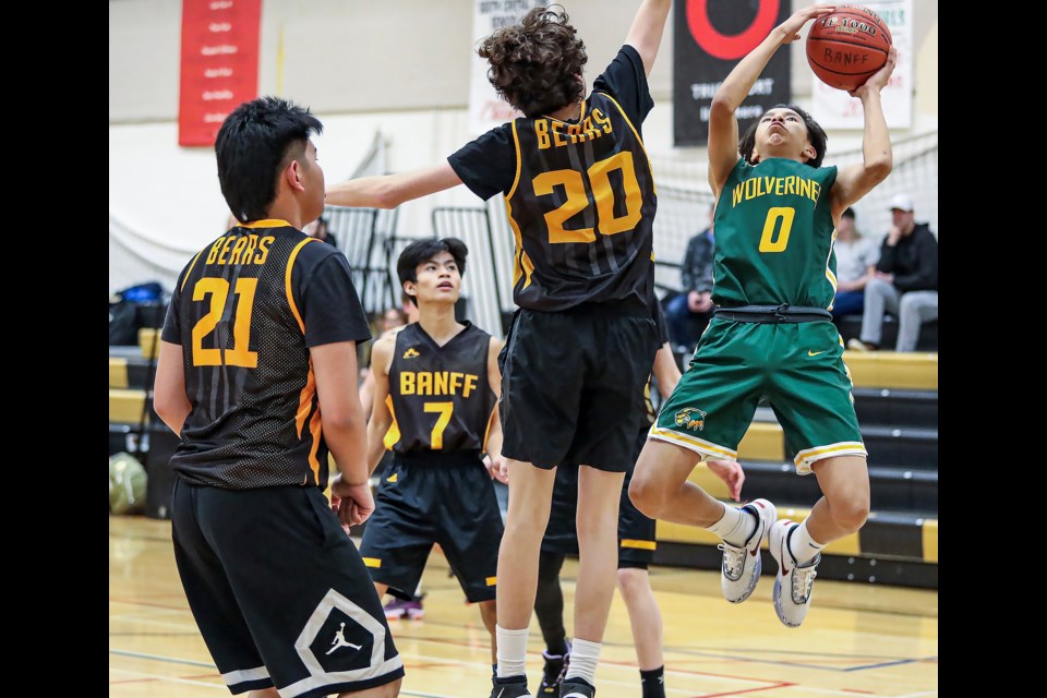 Canmore Wolverines Jonah Mark shoots over the block of the Banff Bears Kai Rauhaus in boys basketball game at Banff Community High School on Wednesday (Feb. 15). JUNGMIN HAM RMO PHOTO