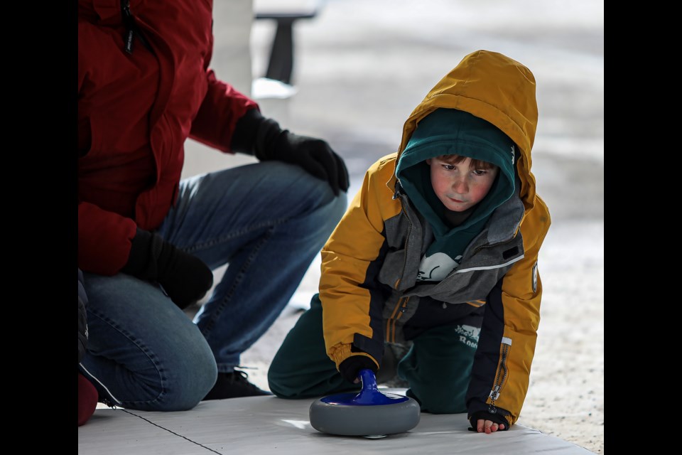 Patrick Kalmakoff plays street curling at the Curling Day in Canada Festival on Bear Street in Banff on Saturday (Feb. 25). JUNGMIN HAM RMO PHOTO 