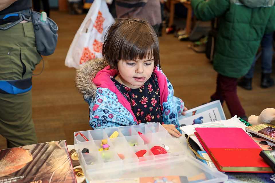 Joanna Deurzen picks free books at the second full moon swap event at the Canmore Public Library on Saturday (March 11). JUNGMIN HAM RMO PHOTO