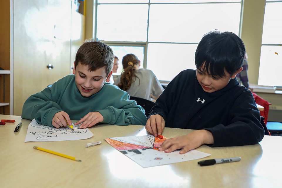 Grade 5 student Connor Gianandrea, left, and Evan Yabut paint landscapes during a drawing session at the art program at Our Lady of the Snows Catholic Academy in Canmore on Tuesday (March 14). JUNGMIN HAM RMO PHOTO