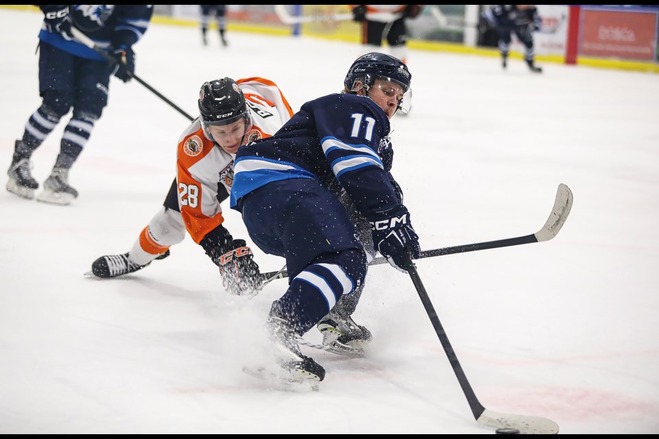 Canmore Eagles captain Vincent Scott battles for a loose puck during the Game 3 against the Drumheller Dragons at the Canmore Recreation Centre on Tuesday (March 14). JUNGMIN HAM RMO PHOTO