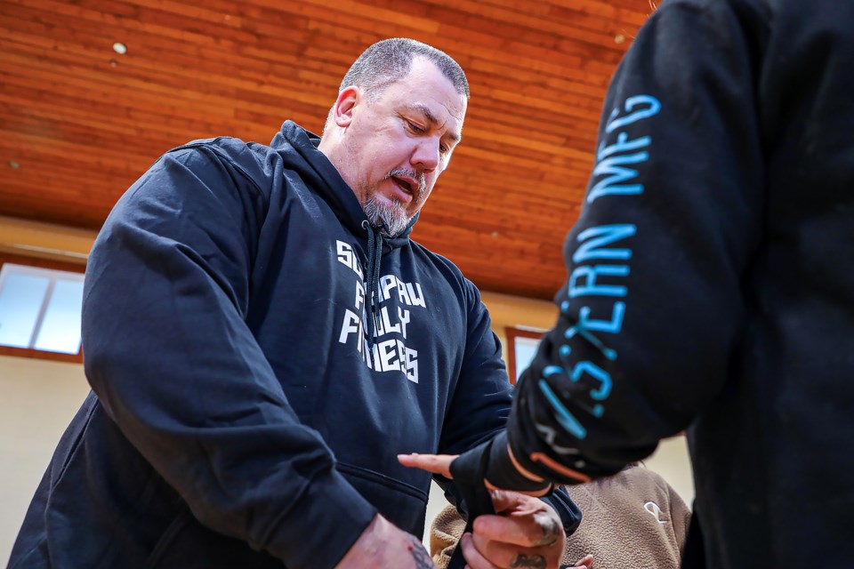 Coach Warren Grenier, left,  helps Kyra Beaver wrap her hands at the Bearspaw Boxing Club practice at the Bearspaw Youth Centre in Mînî Thnî  (Morley) on Thursday (March 30). JUNGMIN HAM RMO PHOTO 