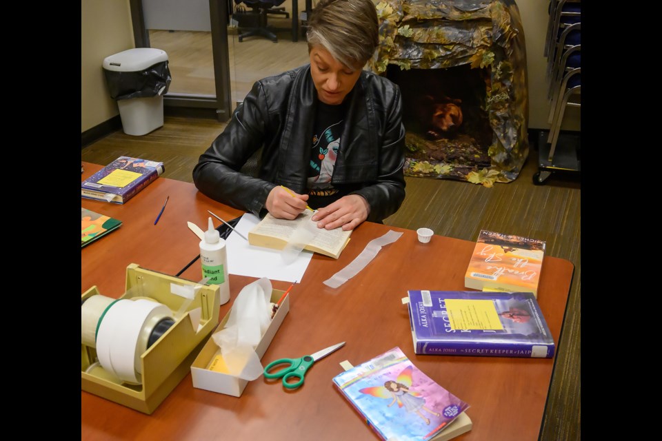 Desorea Komar repairs a book's spine at the Canmore Public Library in April. The goal of mending the books is so they can last until they are pulled from the shelves. The books repaired in the Canmore Public Library are all done in-house. MATTHEW THOMPSON RMO PHOTO