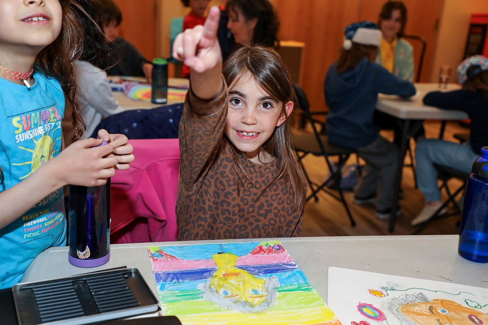 Banff Elementary School Grade 2 student Aria Irwin raises her hand after finishing her portrait during the Intergenerational Portraits event at Banff Public Library on on Thursday (April 27). All portraits will be exhibited at the library KIDS ART SHOW in June. JUNGMIN HAM RMO PHOTO