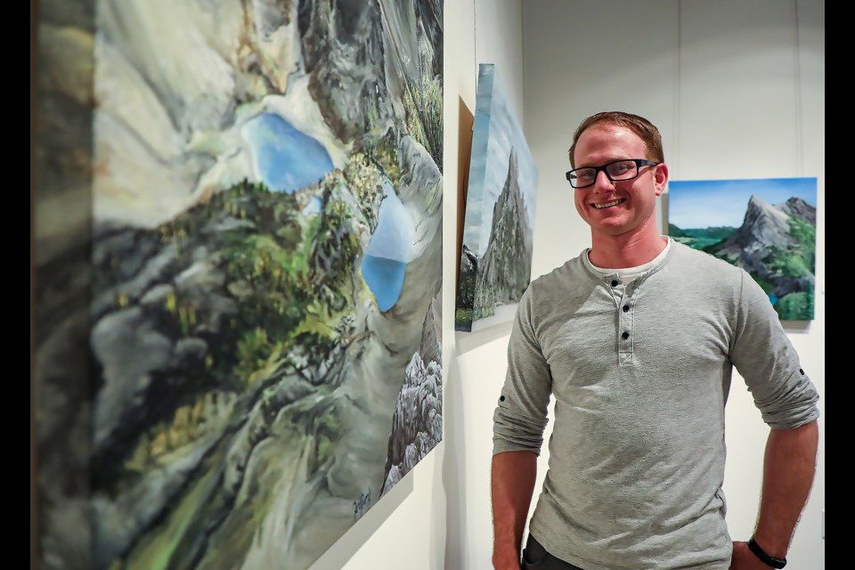 Jon Prom poses in front of his works at the Canmore Art Guild's May exhibit on Saturday (April 29). JUNGMIN HAM RMO PHOTO
