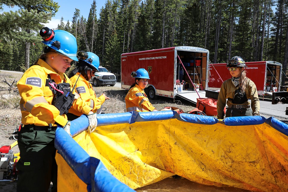 Women firefighters live demonstration of sprinkler and fire hose setup at the Women-in-Fire Training Exchange (WTREX) in front of the Rocky Mountain Resort in Banff National Park on Wednesday (May 3). JUNGMIN HAM RMO PHOTO 