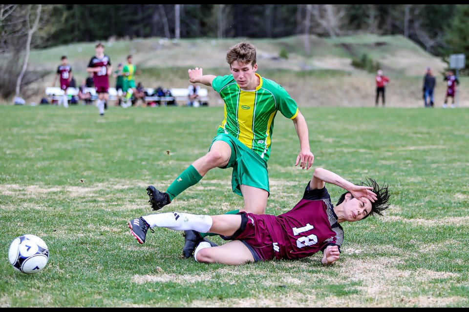 Canmore Wolverines Kai Perron gets tackled by a Foothills Composite High School Falcons defender during a game at Millennium Field in Canmore on Wednesday (May 10). The Wolverines defeated the Falcons 2-0. JUNGMIN HAM RMO PHOTO