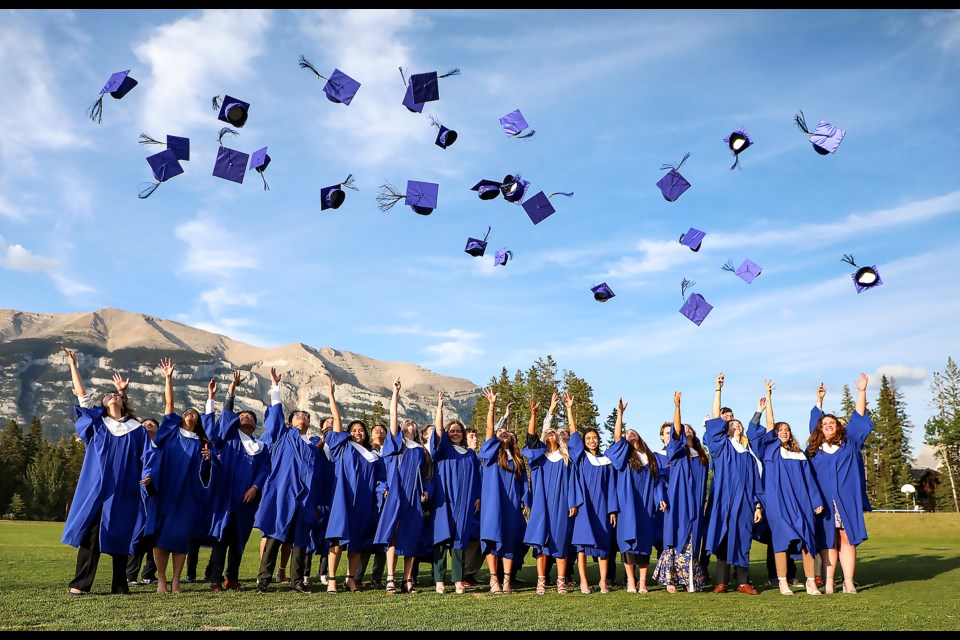 Our Lady of the Snows Catholic Academy graduates toss their mortarboards in the air at Our Lady of the Snows Catholic Academy field in Canmore on Thursday (June 8). JUNGMIN HAM RMO PHOTO