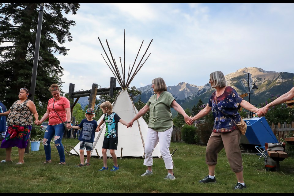 Travis Jimmy John and his partner Ranine Ryder's family and participants do a round dance together during the teepee raising ceremony at the Northwest Mounted Police (NWMP) Barracks in Canmore on Saturday (June 10). JUNGMIN HAM RMO PHOTO