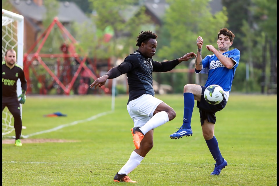 Alton Green, left, of the Banff Springs FC soccer team kicks the ball towards the Rundle FC net during a match in the Bow Valley Soccer League at Our Lady of the Snows Catholic Academy Field in Canmore on Thursday (June 15). The Banff Springs FC defeated Rundle FC 3-1. JUNGMIN HAM RMO PHOTO