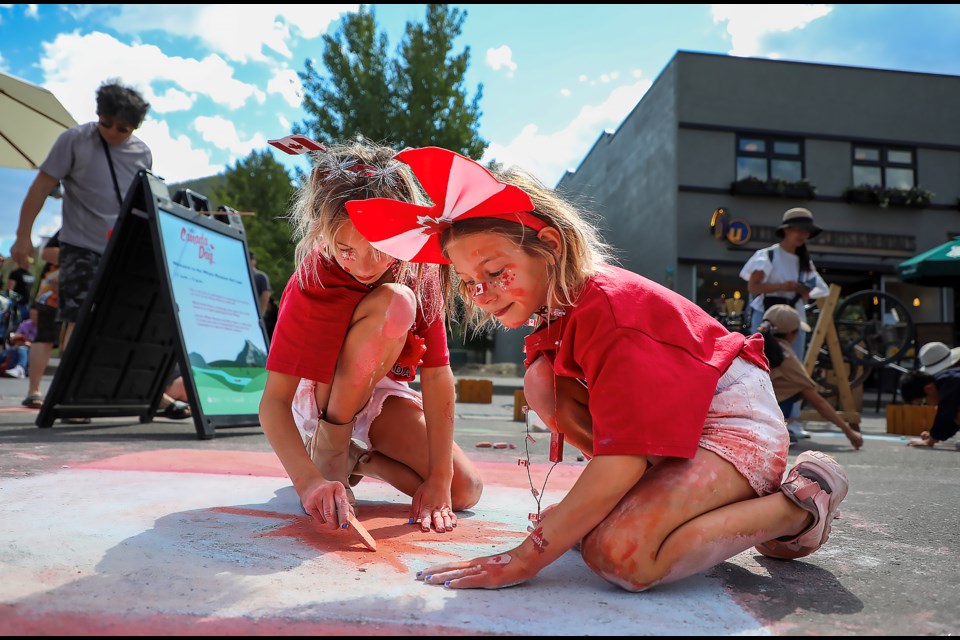 Hadlee Schmidt, 6, right, and Liv Schmidt, 9, draw the Canadian national flag with chalk at the Art Lane hosted by the Whyte Museum on the Banff Avenue pedestrian zone on Saturday (July 1). JUNGMIN HAM RMO PHOTO