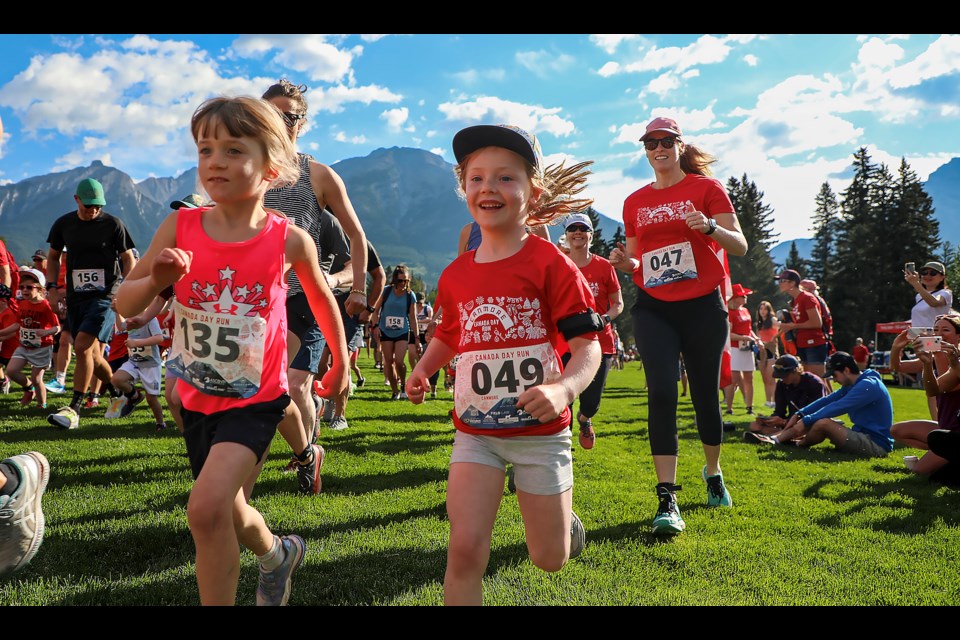 Canmore’s Rosie McPartlin (No. 49) and Harriet Imrie (No. 135) run with a smile in the opening moments of the three-kilometre race in the Canada Day family fun, run and walk on Saturday (July 1) in Canmore. JUNGMIN HAM RMO PHOTO