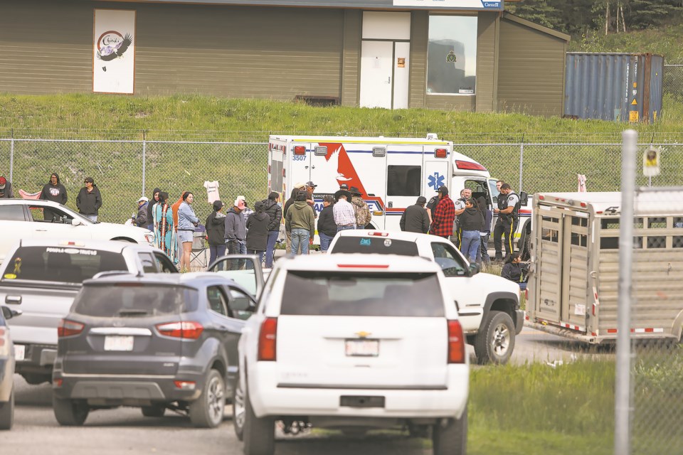 People gather in the parking lot at the Stoney Nakoda RCMP detachment after a bull rider was fatally injured in competition at the Chiniki Rodeo Grounds on Îyârhe (Stoney) Nakoda First Nation Sunday (July 2).

JUNGMIN HAM RMO PHOTO 