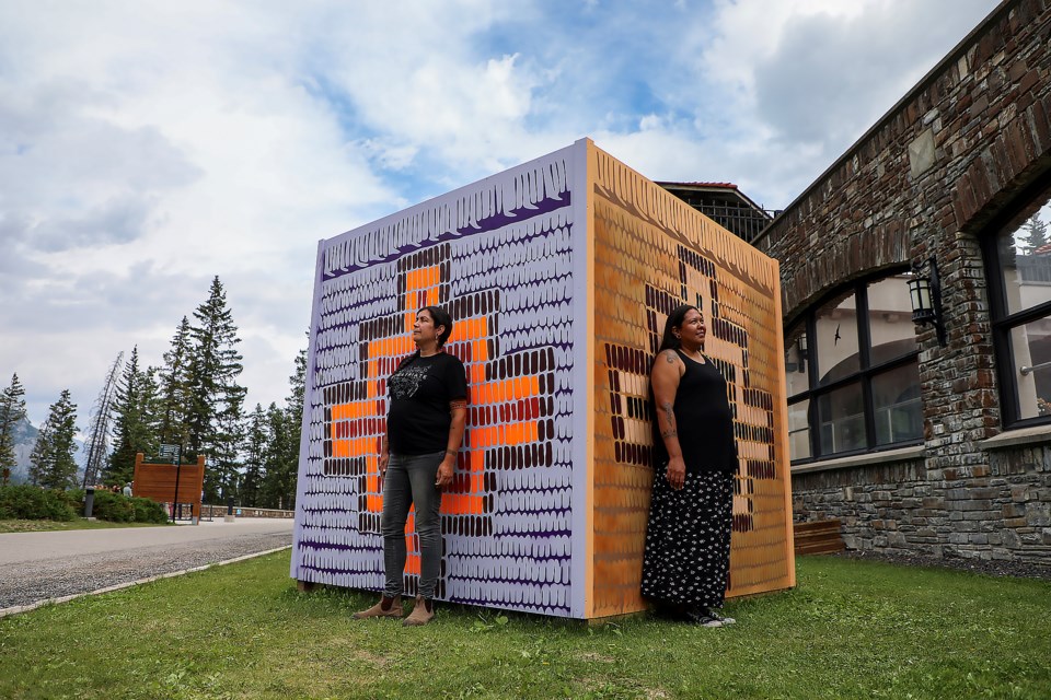 Secwépemc's Tania Willard, left, and Ktunaxa and Secwépemc's Snutetkwe Manuel pose in front of mural artwork at the Cave and Basin National Historic Site in Banff National Park on Tuesday (July 4). JUNGMIN HAM RMO PHOTO