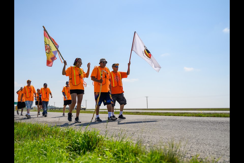 Sobercrew treks along the Trans-Canada Highway on Thursday (Aug. 3) back to Mînî Thnî during the Ama'hna'bino walk, which was organized to raise awareness around and in support of those who have lost their lives to addiction, suicide or violence. MATTHEW THOMPSON RMO PHOTO
