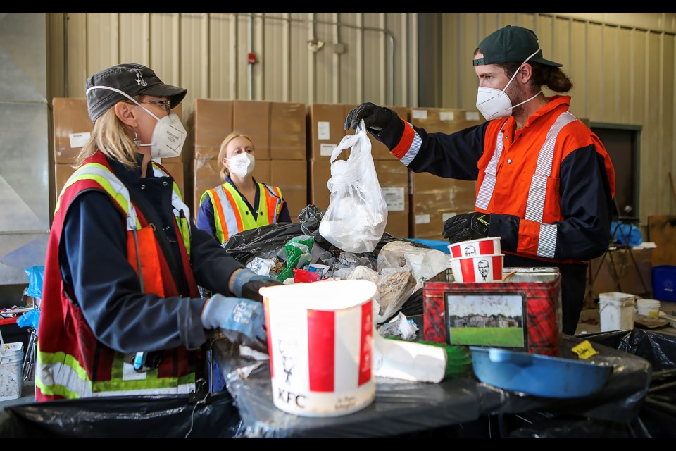 S-Cubed Environmental's consultants Stacey Schaub-Szabo, left, Georgia Boston and Reuben Honoŕe do a waste audit at Canmore Waste Management Centre on Tuesday (Aug. 29). JUNGMIN HAM RMO PHOTO 
